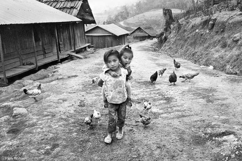 동생을 등에 업고 · Phunoi village, Boun Neua, Phongsali, Laos, 2011 · 박노해 · ParkNohae · ⓒParkNohae (이미지 제공 = 라 카페 갤러리) · ⓒParkNohae (Source = Ra Cafe Gallery)